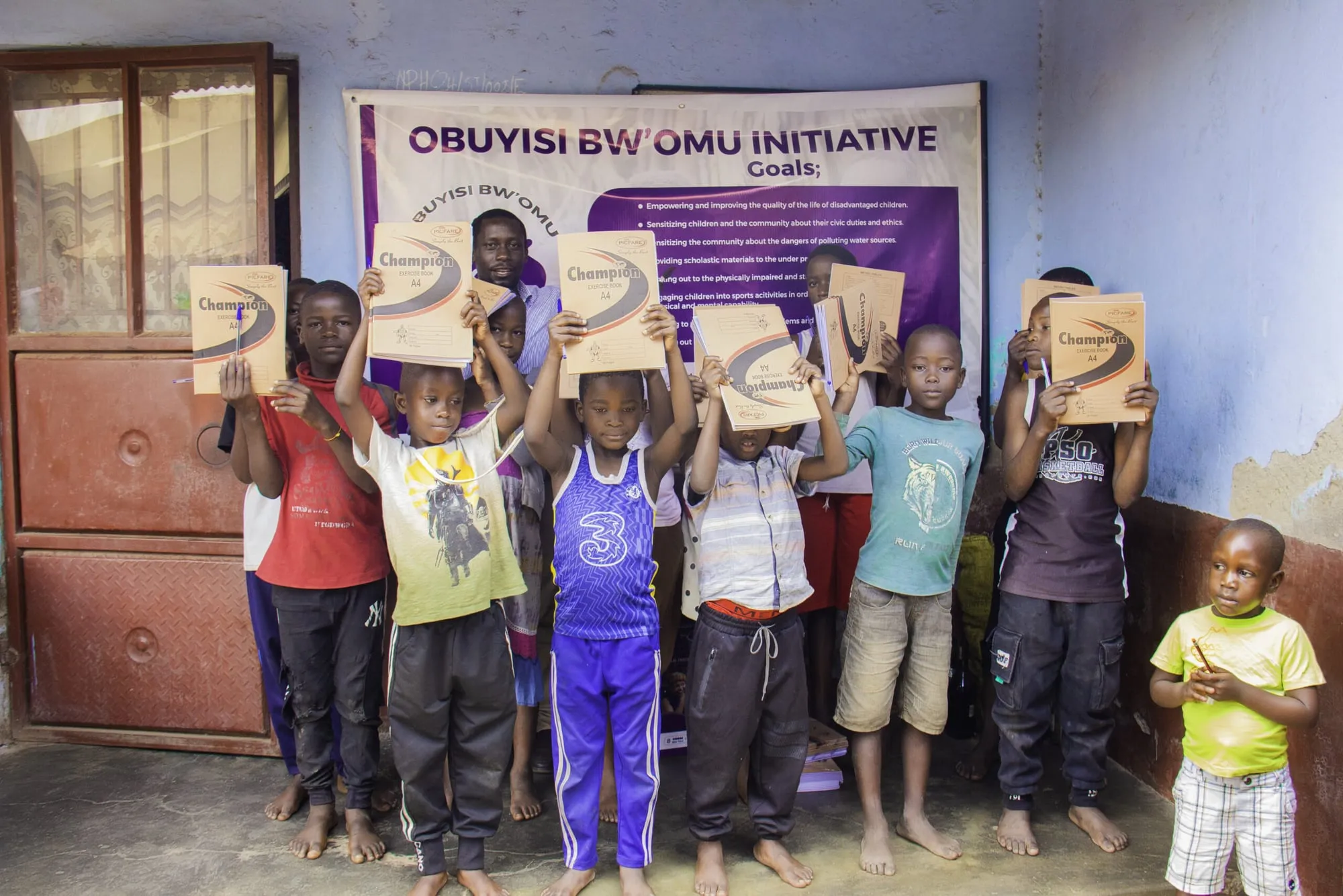 Children holding up exercise books received from the campaign