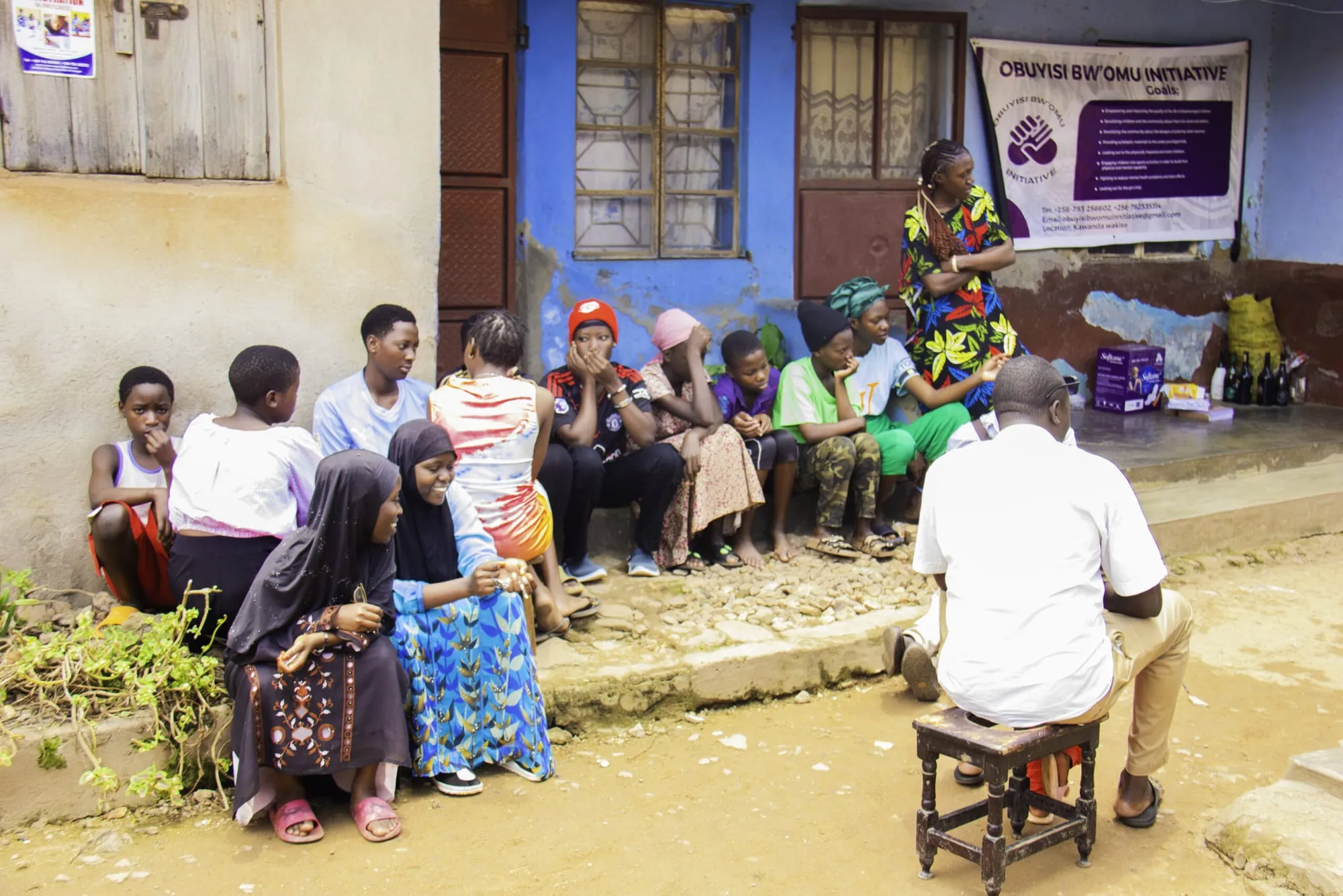 Young people seated together during a community mental health conversation in Bwaise